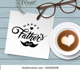 Flat lay style father`s day greeting card with cup of coffee and glasses on wooden table.