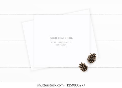 Flat lay top view elegant white composition paper brown pine cone on wooden background. Xmas decoration design.