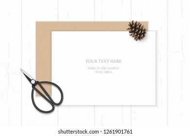 Flat lay top view elegant white composition paper kraft envelope pine cone and vintage metal scissors on wooden background.