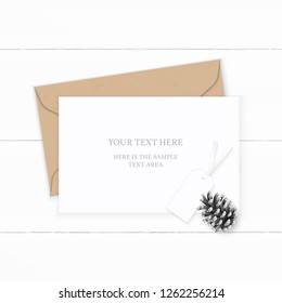Flat lay top view elegant white composition letter kraft paper envelope pine cone and tag on wooden background.