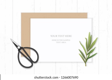 Flat lay top view elegant white composition paper kraft envelope tarragon leaf and vintage metal scissors on wooden background.