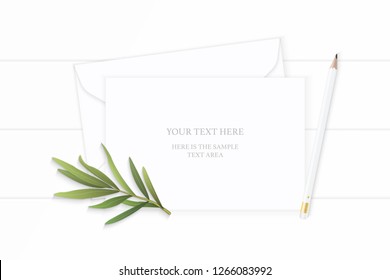 Flat lay top view elegant white composition paper envelope pencil tarragon leaf on wooden background.