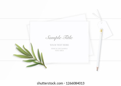 Flat lay top view elegant white Christmas composition paper pencil tag tarragon leaf on wooden background.