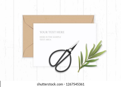 Flat lay top view elegant white composition letter kraft paper envelope tarragon leaf and vintage metal scissors on wooden background.