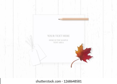 Flat lay top view elegant white composition paper autumn red maple leaf pencil and cardboard tags on wooden background.