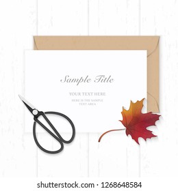 Flat lay top view elegant white composition paper kraft envelope autumn red maple leaf and vintage metal scissors on wooden background.