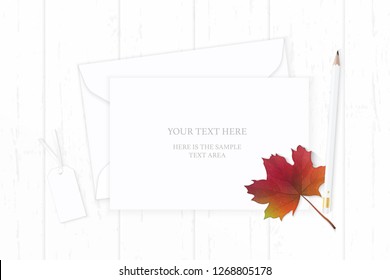Flat lay top view elegant white composition paper envelope pencil tag and autumn maple leaf on wooden background.
