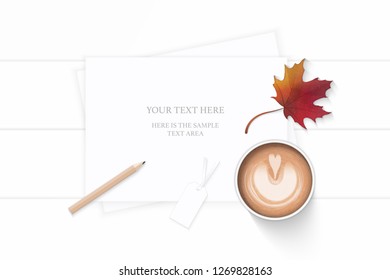 Flat lay top view elegant white composition paper coffee tag pencil and autumn maple leaf on wooden background.