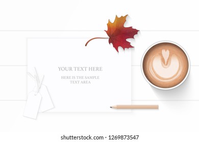 Flat lay top view elegant white composition paper pencil autumn maple leaf tag and coffee on wooden background.