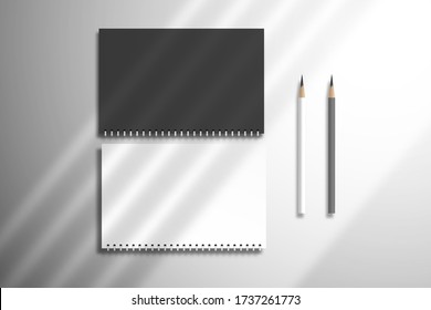 Flat lay with two blank spiral notebooks and pencils. Mockup for design with realistic diagonal shadow