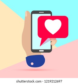 flat minimal hand holding mobile phone with pink heart like social media icon on pastel colored blue and pink background. Pink bubble  icon set for live stream video, chat, likes, websites, blog
