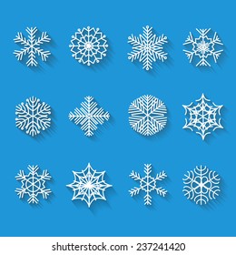 Flat snowflakes. Icons isolated on a blue background. Set  with long shadows. Elements of various shape for your design. Vector illustration.