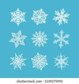 Flat snowflakes.  Winter set of white snowflakes isolated icon silhouette on blue background.