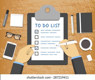 Flat 'To Do List' concept - hands over clipboard on top of wooden desk
