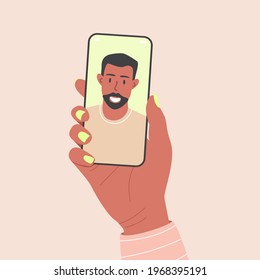 Flat vector cartoon illustration of a female hand holding a phone with a man on the screen. An app for dating, video calls, and online conferences.