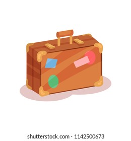 Flat vector icon of vintage suitcase with colorful stickers. Brown travel bag with little handle, golden corners and locks