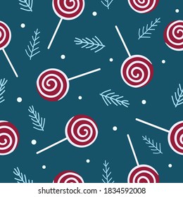 Flat white and red lollipops, fir branches and snow on blue background. Christmas winter sweet pattern. Suitable for packaging, textile, wallpaper.