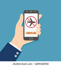 Flight cancelled. Hand holding smartphone with flight cancelled information