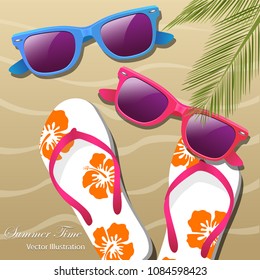 Flip- flops in the sand, sun glasses and palm leaves