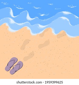 Flip flops and steps on the sand by the sea. Sandy beach with waves, sea foam and flip flops with human footprints in the sand.Summer vacation concept on the sandy beach of the ocean.