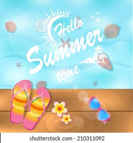 Flip-flops and sunglasses near water on wooden deck