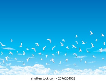 A flock of birds flapping in the open blue sky