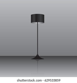 Floor lamp with a black lampshade on the floor with a reflective surface.