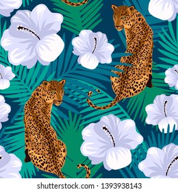 Floral jungle leopard seamless pattern.  Animal print pattern with tropical leaves and flowers in deep blue background.