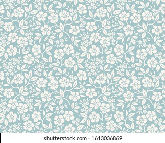 Floral pattern. Pretty flowers on gray blue background. Printing with small white flowers. Ditsy print. Seamless vector texture. Spring bouquet.