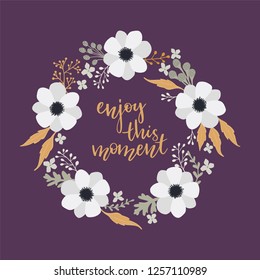 Floral round wreath frame with Enjoy this moment calligraphy. 