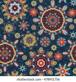 Floral seamless pattern with stylized snowflakes. Beige red yellow snowflake on blue background.