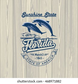 Florida, Sunshine State, stylized emblem of the state of America, Dolphin, on wooden background