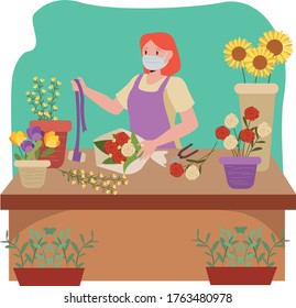 Florist is making a flower bucket while keep using medical mask