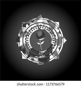 flower icon inside grey camouflaged emblem