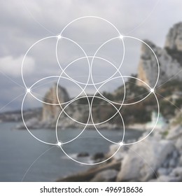 Flower of life - the interlocking circles ancient symbol in front of blurred photorealistic nature background. Sacred geometry - mathematics, nature, and spirituality in nature. The formula of nature.