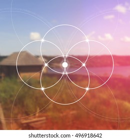 Flower of life - the interlocking circles ancient symbol in front of blurred photorealistic nature background. Sacred geometry - mathematics, nature, and spirituality in nature. The formula of nature.