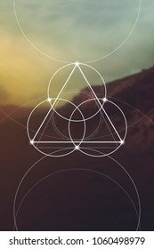 Flower of life interlocking circles and triangles sacred geometry illustration with golden ratio digits in front of photographic background.