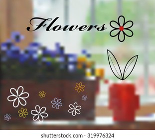 Flowers and a red watering can on a background of a window