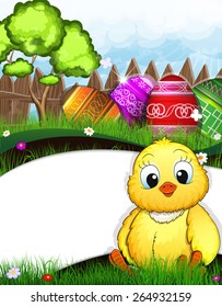 Fluffy chicken sitting in the grass in the meadow. Painted Easter eggs and green tree near a wooden fence in the background