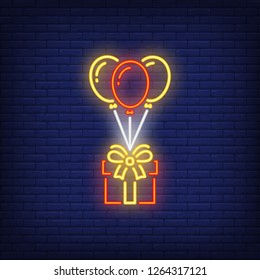 Flying balloons with gift box neon sign. Birthday party design element. Night bright neon sign, colorful billboard, light banner. Vector illustration in neon style.