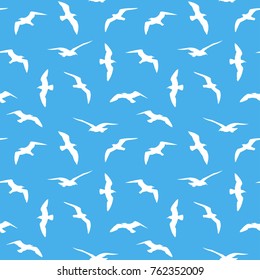 Flying birds silhouettes seamless pattern. White birds silhouettes on blue background. Vector colored endless texture.