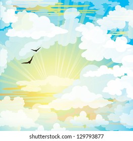 Flying black birds on a sunset cloudy sky.