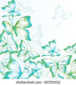 Flying green-white-blue butterflies on a light background
