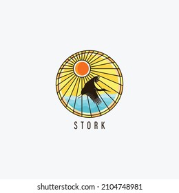 Flying Stork on the blue sea logo design with sunrise or sunset as the background. The black bird flying