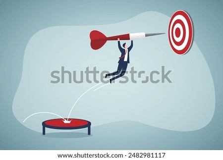 Focus on business goal, reaching target or achievement, achieve business objective or purpose, motivation to success concept, Businessman holding dart, bounce on trampoline jumping right to dartboard.