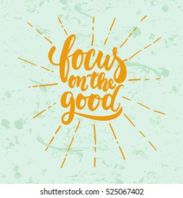 Focus on the good- hand drawn lettering phrase isolated on the green grunge background. Fun brush ink inscription for photo overlays, greeting card or t-shirt print, poster design