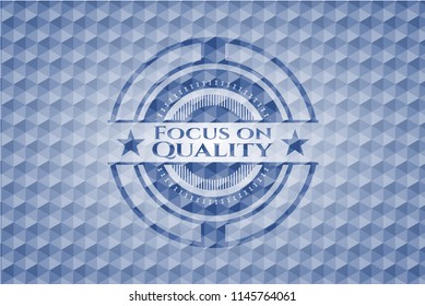 Focus on Quality blue emblem or badge with abstract geometric pattern background.