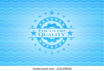 Focus on Quality sky blue water wave badge.