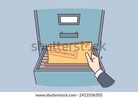 Folder with confidential documents inside safe and hand of person taking out archival papers. Person steals confidential data and commits corporate espionage to obtain insider information.