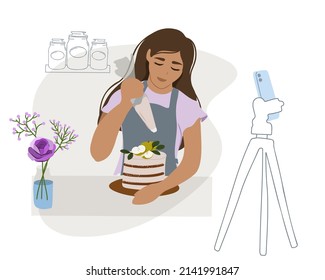 Food blogger preparing a cake. A woman in the kitchen communicates with subscribers through a smartphone camera. Online course, master class, stream, broadcast, distance learning or remote work. 